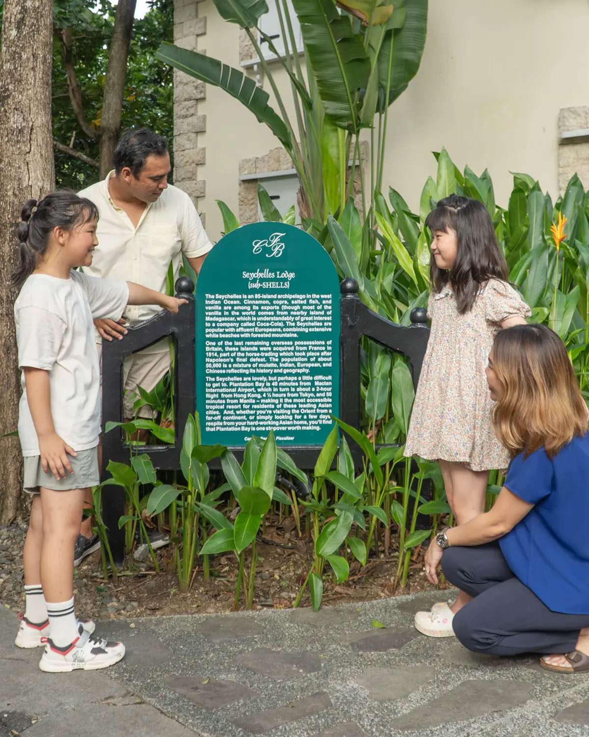 A family reading a building sign on the Name-Game Quiz