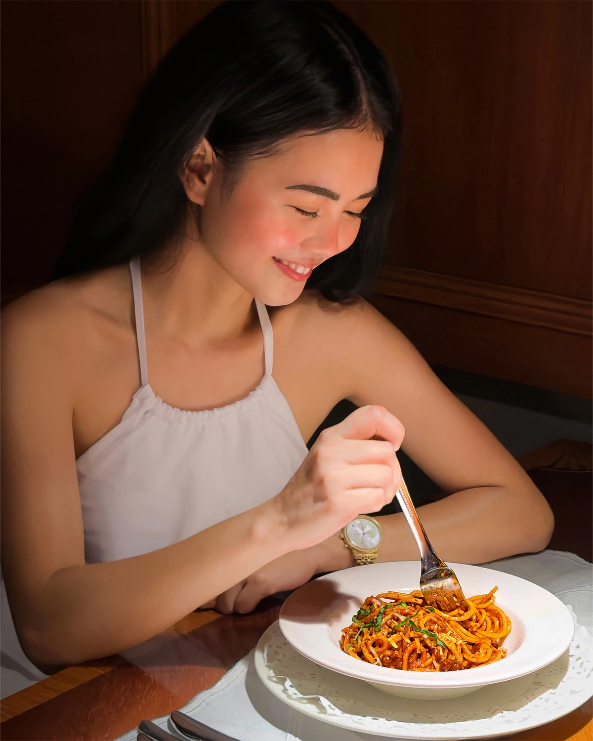A guest smiling over a plate of spaghetti Bolognese at Palermo