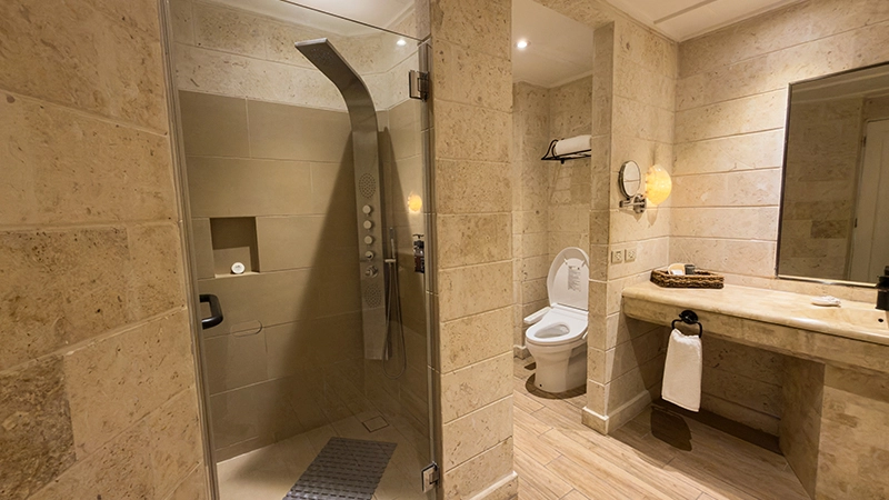 Beachside One-Bedroom Suite stone bathroom with glass walk-in shower
