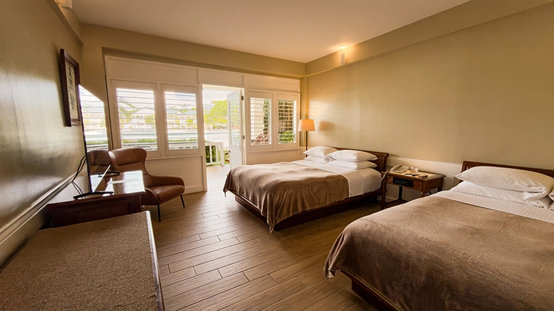 Beachside One-Bedroom Suite bedroom with shuttered doors opening onto the veranda