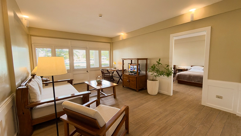 Beachside One-Bedroom Suite living room with wooden-frame sofa and armchair