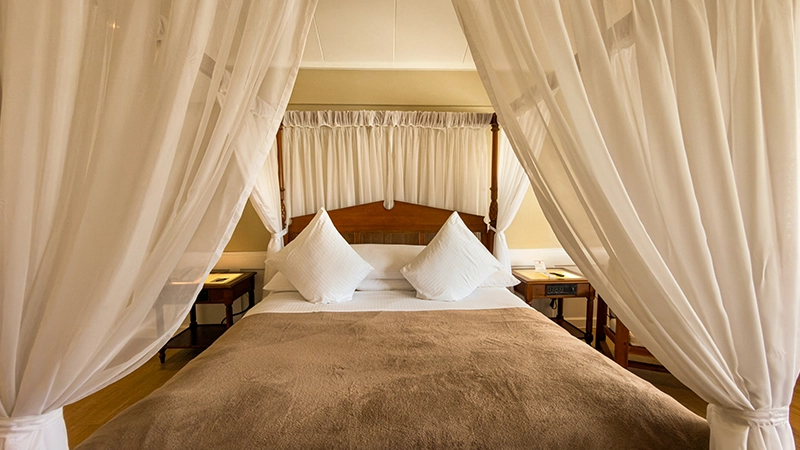 Canopied four-poster king bed in the Beachside Two-Bedroom Suite master bedroom
