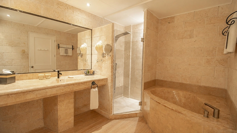 Deluxe Poolside stone bathroom with glass shower and corner soaking tub