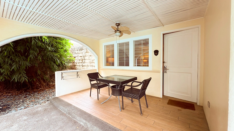 Deluxe Poolside covered veranda with glass-top dining table and wicker chairs