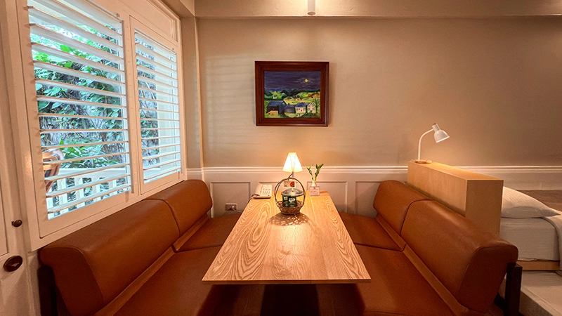 Fourplex Room flexible lounging-working area with two leather banquette sofas and a wooden dining table