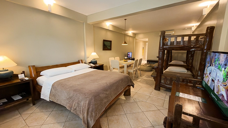 Friends-and-Family Room double bed with log bunk beds and dining table beyond