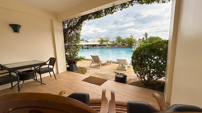 Ground-Floor Beachside Room covered terrace opening directly onto the sandy lagoon edge