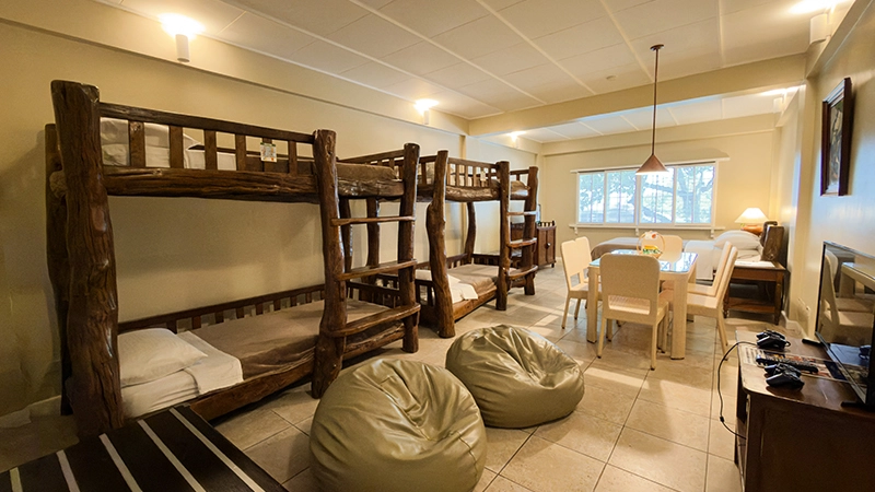 Smoking-Permitted Room with log bunk beds, dining table, bean bags, and beds by the window