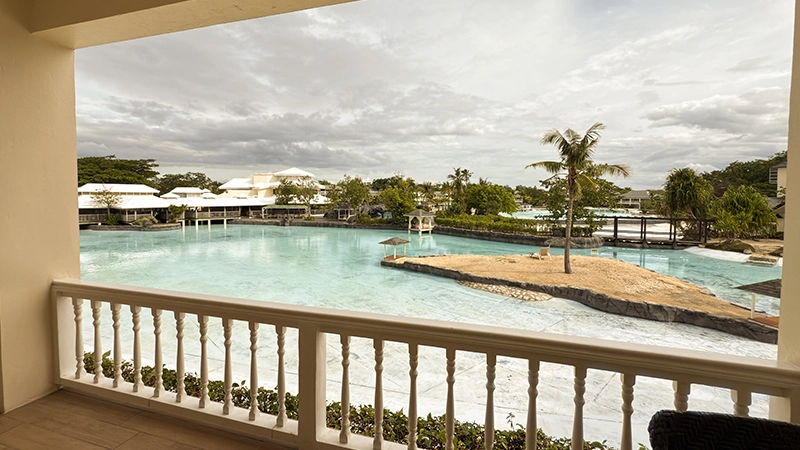 Balcony view over the swimming lagoon from the Upper-Floor Beachside Room