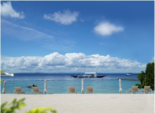 White-sand beach with loungers and a banca on the sea